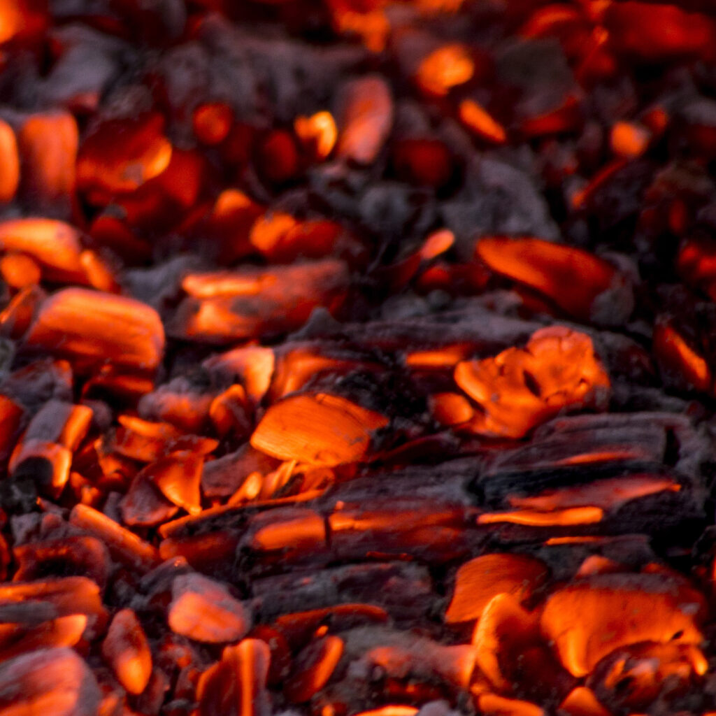 Glowing hot charcoal briquettes background texture